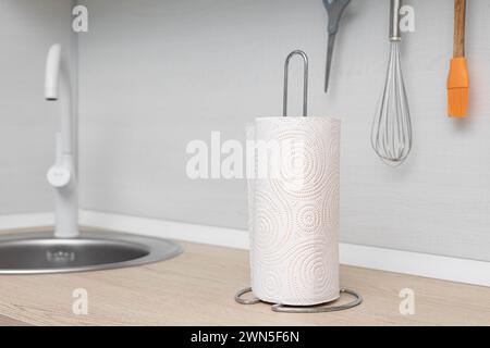 The kitchen towel holder stands on the kitchen countertop. paper towel in the kitchen. paper towel holder Stock Photo