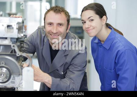 man explains woman how to use a machine in factory Stock Photo