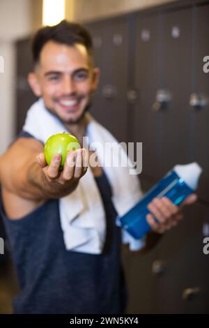 young happy man holding water bottle and red apple ready Stock Photo