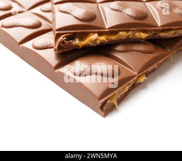 Broken chocolate filled with caramel and peanuts, isolated on a white background. Pastry shop concept. The filling flows out of the chocolate broken Stock Photo
