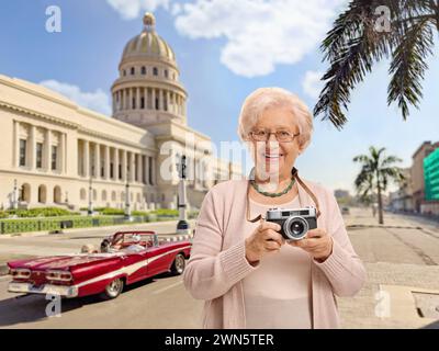 Elderly female tourist with a vintage camera in Havana, Cuba Stock Photo