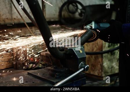 Closeup of unrecognizable man using angle grinder while doing metalwork, copy space Stock Photo