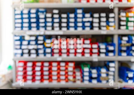 Blurred background with shelves with a large number of trays with fasteners, accessories and small consumables in the building materials store Stock Photo