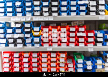 Blurred background with shelves with a large number of trays with fasteners, accessories and small consumables in the building materials store Stock Photo