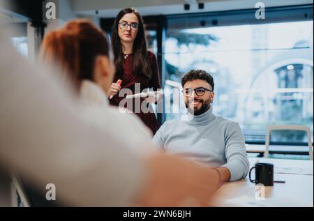 Colleagues discuss financial planning and market analysis in a corporate office. They collaborate on a project, strategizing for success. Stock Photo