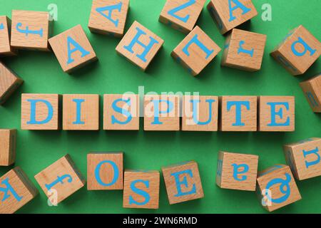 Cubes with word Dispute on green background, flat lay Stock Photo