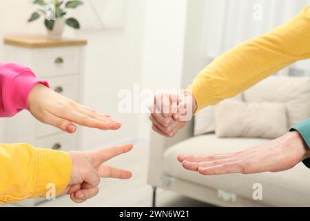 People playing rock, paper and scissors indoors, closeup Stock Photo