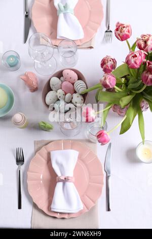 Festive table setting with beautiful flowers, flat lay. Easter celebration Stock Photo