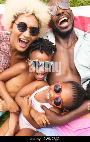 African American family is enjoying a sunny day outdoors, lying on a blanket Stock Photo