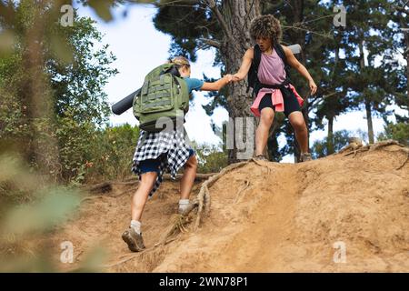 Two women team up for an adventurous hike, showcasing unity. Stock Photo