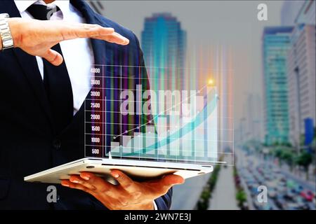 business man using laptop showing graphic earning company chart of this year Stock Photo
