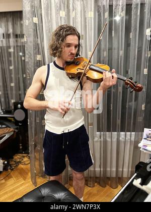 Young handsome man playing violin at home Stock Photo