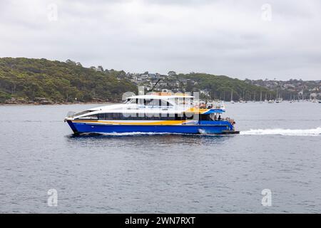 NRMA fast ferry between manly and Circular Quay travels across Sydney harbour with headland background,Sydney,NSW,Australia Stock Photo