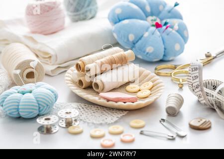 Still life of sewing utensils with buttons, threads, pins Stock Photo