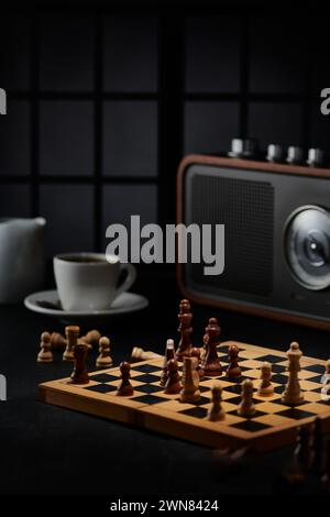 Photo of a chess game board, glasses and a radio in a room Stock Photo