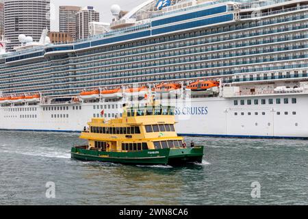 Cruise ship Majestic Princess moored in Sydney circular quay with Sydney ferry MV Fishburn cruising past,New South Wales,Australia,2024 Stock Photo