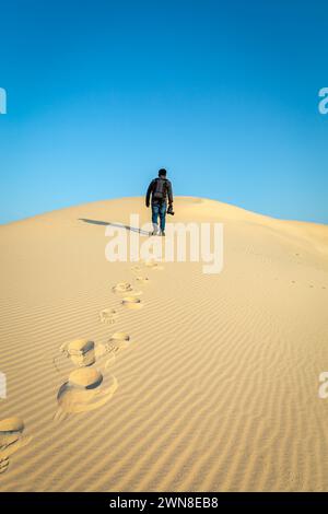 A male Photographer step by step walking on Desert Landscape in Abqaiq Dammam Saudi Arabia. Stock Photo