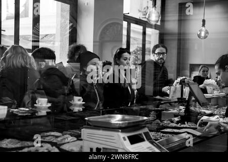 People wait to be served at the pastry shop counter, the photograph was taken in Parma on 11/25/2023 Stock Photo