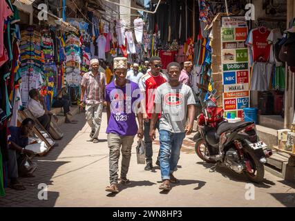 Young men walk in Darajani Market in Zanzibar City, Zanzibar, Tanzania Stock Photo