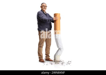 Full length portrait of a happy mature man putting off a big cigarette isolated on white background, give up smoking concept Stock Photo