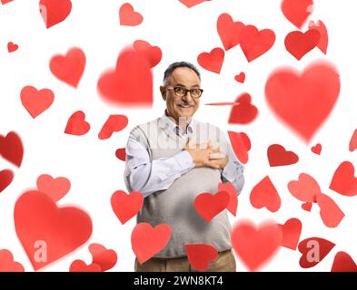 Smiling mature man expressing love under falling hearts isolated on white background Stock Photo