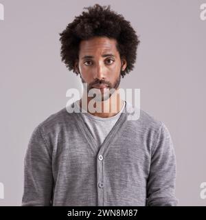 Afro, studio and portrait of man with fashion for trendy, clothes and cool style on gray background. Jersey, black person and serious face with Stock Photo