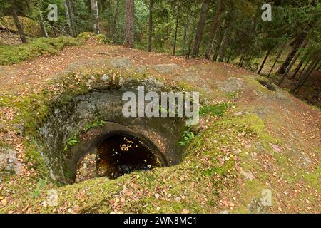 Cylindrical Talvia Giant´s kettles (giant´s cauldron, moulin pothole, or glacial pothole) drilled in solid rock in forest in autumn with leaves on the Stock Photo