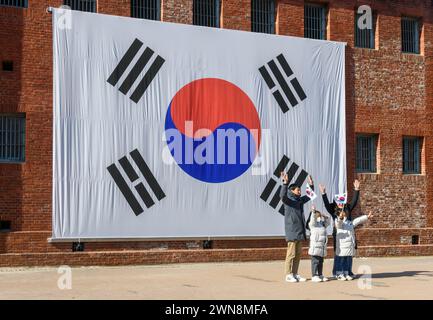 Seoul, South Korea. 01st Mar, 2024. A South Korean family takes pictures in front of a huge national flag during the celebration of the Korean Independence Movement Day in Seoul. The Korean Independence Movement Day, also known as the March 1st Movement, was an important protest movement of Koreans in early 1919 demanding independence from Japan and an end to forced assimilation into Japanese culture. Credit: SOPA Images Limited/Alamy Live News Stock Photo