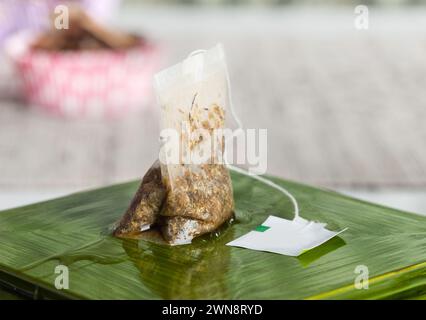 Used teabag resting on green dish Stock Photo