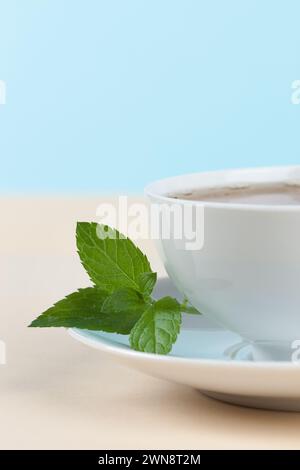 Fresh mint tea in white cup on beige Stock Photo