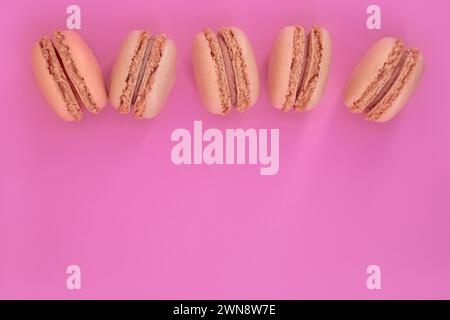 Five white french macaroons on a pink background Stock Photo