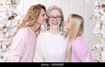 Celebration of International Women's Day. Mother and granddaughter hugging and kissing with grandmother, expressing their love and appreciation on thi Stock Photo