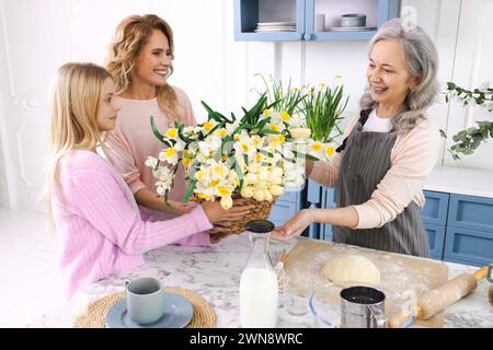 Mother and daughter congratulate grandmother on Mother's Day. Women from three generations of same family celebrating Mother's Day together Stock Photo