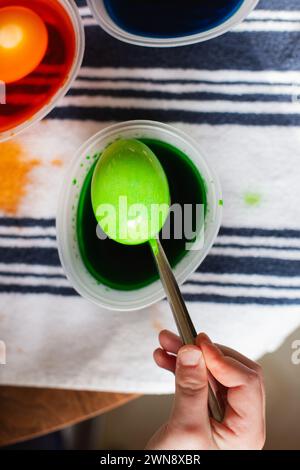 Green dyed Easter egg on a metal spoon Stock Photo