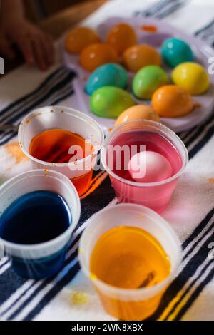Close up of easter eggs in food coloring cups Stock Photo