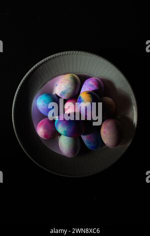 Colorful Dyed Easter eggs in a white ceramic bowl Stock Photo