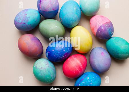 Brightly colored dyed Easter eggs against pink backdrop Stock Photo