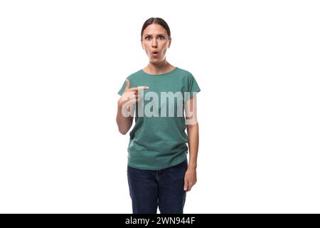 young serious black-haired woman with collected hair is dressed in a basic t-shirt and jeans Stock Photo