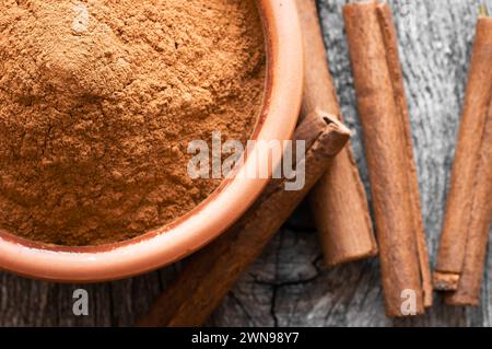 Cinnamon sticks and cinnamon powder on dark rustic background, healthy spice, (Cinnamomum) Stock Photo