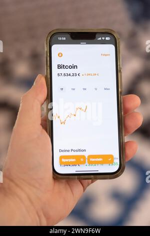 Hand holding a mobile phone with a Bitcoin chart Stock Photo