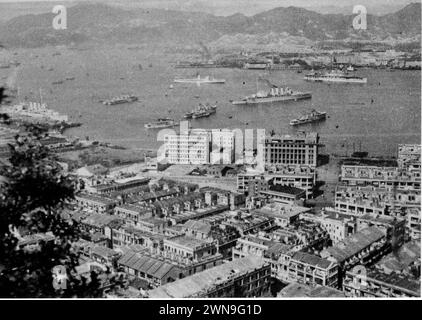 Ships of the Royal Navy's China Fleet at anchor in Hong Kong harbour during the 1930s. Presence of aircraft carrier HMS Eagle (top right) dates the photo to either 1934 or 1937-39. Two 3-funnel County-class heavy cruisers and several destroyers also seen Stock Photo