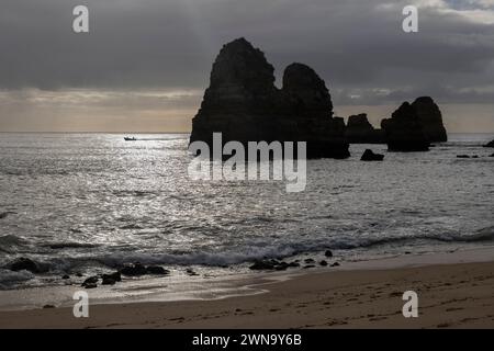 Algarve coast with sun reflection in water and majestic rock formations in ocean, Lagos, southern Portugal. Stock Photo