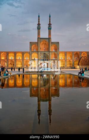 Takyeh (building where Shia Muslims gather to mourn Husayn's death) and minarets of the Amir Chakhmaq Complex reflected in a water pool. Yazd, Iran. Stock Photo