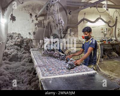 A young man works in a small carpet making workshop. Yazd, Iran. Stock Photo