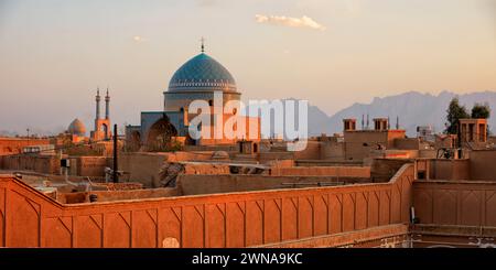 Rooftop view of the Seyed Rokn Addin Mausoleum (14th century) with its beautiful blue tiled dome lit by setting sun. Yazd, Iran. Stock Photo