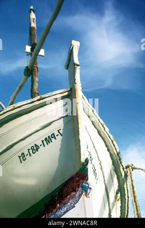 A traditional Mallorcan fishing boat (mall: Llaüt) is reflected in the harbour basin of Porto Cristo. Stock Photo