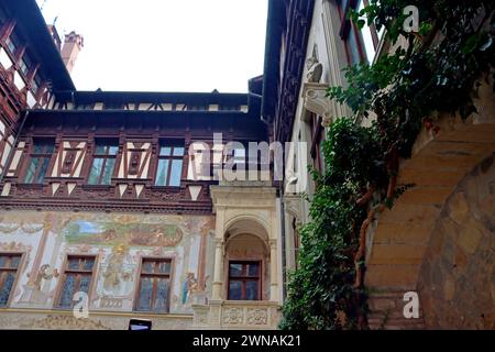 Sinaia, Romania - October 14, 2023: Yard of beautiful Peles castle with painted facade walls and wooden elements Stock Photo