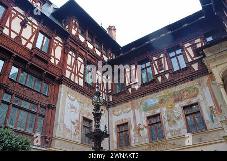 Sinaia, Romania - October 14, 2023: Yard of beautiful Peles castle with painted facade walls and wooden elements Stock Photo