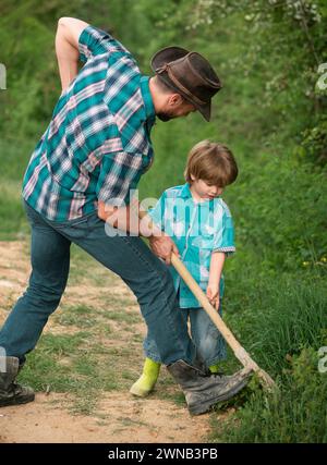 Father and son and wearing shirt planting tree. Stock Photo