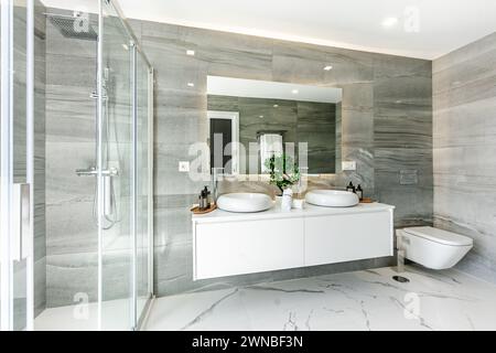 an image of a luxury double sink bathroom with a standing shower a marble walls in a mediterranean villa Stock Photo